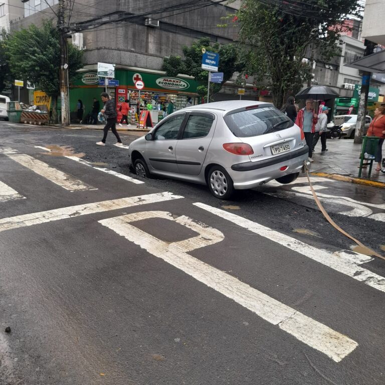Carro fica preso em cratera que abriu em rua de Canoas