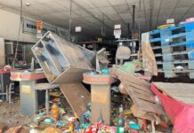 Enchente em Canoas: “O cheiro está insuportável” relata moradora vizinha a supermercado. Pela porta é possível ver o cenário.