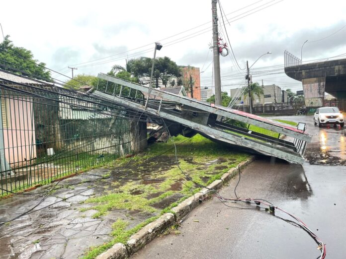 Forte vento derruba outdoor em cima de muro de residência em Canoas