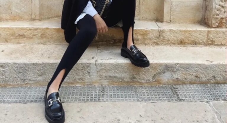 Modelo usando uma calça fusô preta com um pâr de mocassins pretos