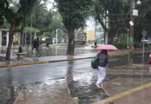 Imagem mostra morador do Rio Grande do Sul caminhando na chuva