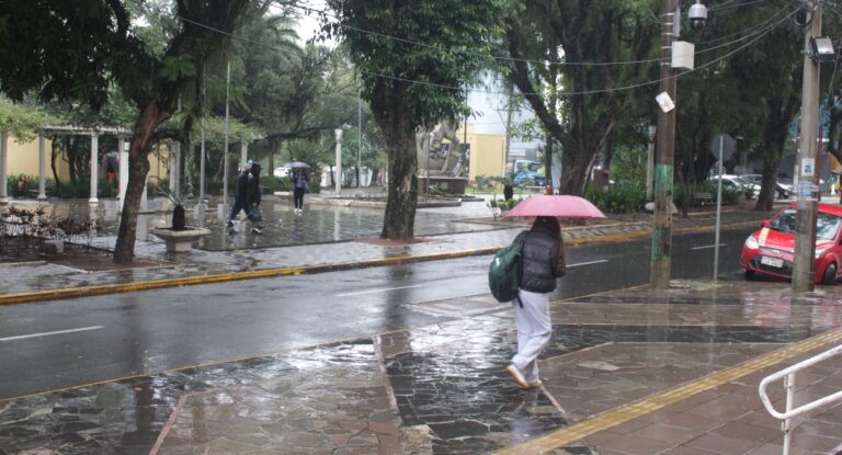 Imagem mostra morador do Rio Grande do Sul caminhando na chuva