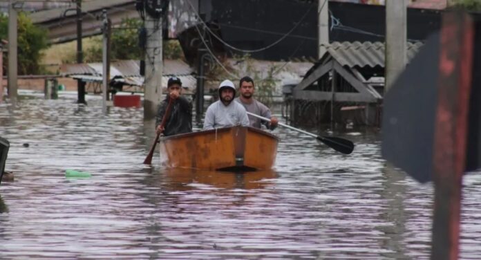 Imagem mostra moradores do Rio Grande do Sul durante enchentes que atingiram o Estado; Estudo aponta que eventos extremos devem ser mais frequentes