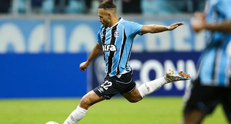 Jogador do grêmio chutando a bola ao gol