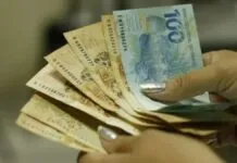 Foto mostra pessoa contando dinheiro; Governo do RS confirma pagamento de auxílio