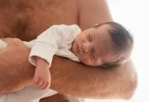 Imagem de um bebe no colo de um homem