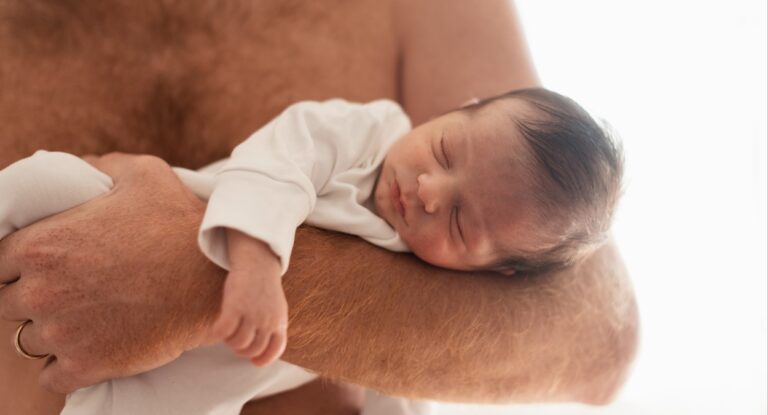 Imagem de um bebe no colo de um homem