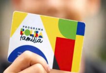 Mão segurando um cartão do Bolsa Família