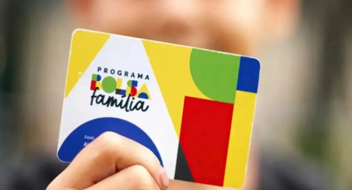 Mão segurando um cartão do Bolsa Família