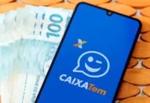 Aplicativo do Caixa Tem com cédulas de cem reais ao fundo