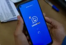 Foto mostra uma pessoa segurando um celular com o aplicativo do Caixa Tem aberto