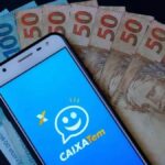Foto mostra aplicativo do Caixa Tem com notas de dinheiro