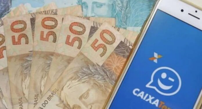 Foto mostra aplicativo do Caixa Tem com notas de dinheiro