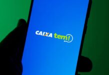 Mão segurando celular com o aplicativo do caixa tem