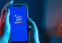 Mão segurando um celular com o aplicativo da Caixa Tem aberto