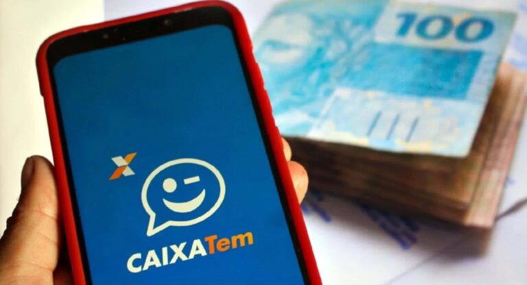 Imagem de celular com app do caixa Tem aberto e cédulas de dinheiro ao fundo