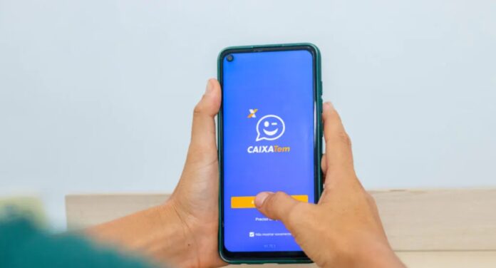 Pessoa segurando um celular com o aplicativo do Caixa Tem aberto