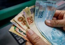 Pagamento em caixa eletrônico com cédulas de cinquenta e cem