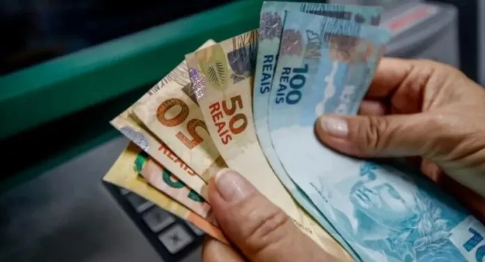 Pagamento em caixa eletrônico com cédulas de cinquenta e cem