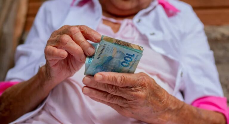 Imagem de idoso com dinheiro da aposentadoria na mão