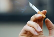 Foto mostra pessoa fumando cigarro, um dos hábitos que alguns brasileiros têm que podem ser crime em alguns países