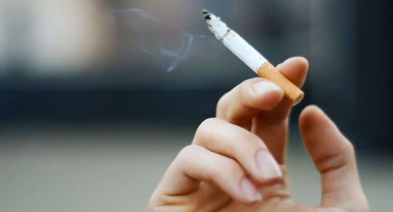 Foto mostra pessoa fumando cigarro, um dos hábitos que alguns brasileiros têm que podem ser crime em alguns países