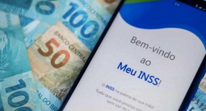 App do Meu INSS aberto em um celular com cédulas de real ao fundo
