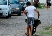 Imagem de menino com um empurrando um carrinho de mão