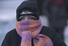 Foto de pessoa agasalhada andando em cidade gelada em meio à questão de trabalhar no frio