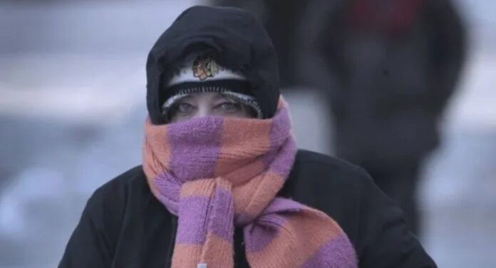 Foto de pessoa agasalhada andando em cidade gelada em meio à questão de trabalhar no frio