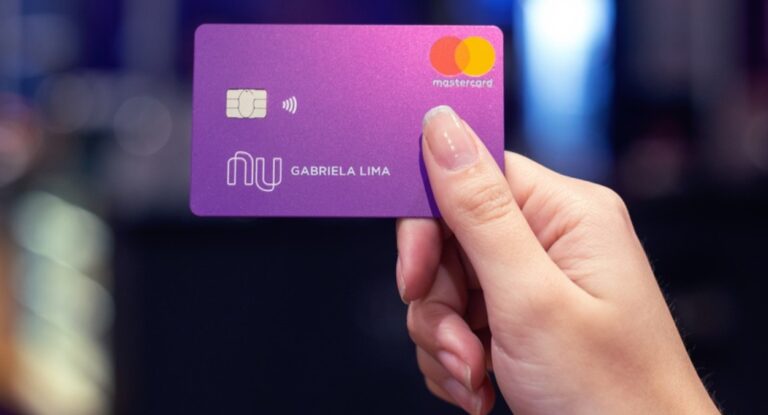 Foto mostra mulher segurando cartão do Nubank