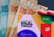 Cartão do Bolsa Família e cédulas de dinheiro no valor de 100 e 50 reais