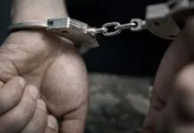 Homem preso com algemas nas mãos