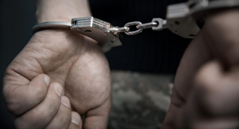 Homem preso com algemas nas mãos