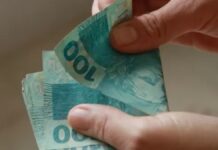 Imagem de trabalhador contando dinheiro do salário mínimo pago em 2025