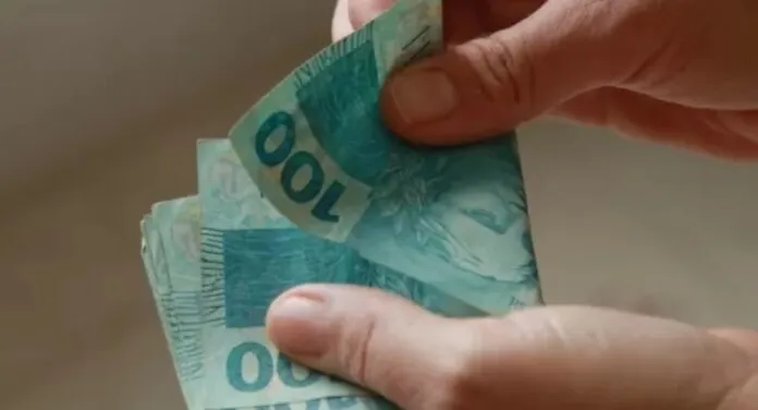Imagem de trabalhador contando dinheiro do salário mínimo pago em 2025