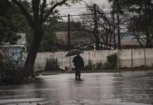 Foto mostra morador de Canoas em meio a alagamento; Pagamento do Volta Por Cima começou a ser pago