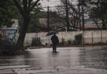 foto de pessoa na chuva possivelmente elegível para auxílio em canoas