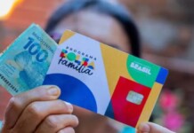Imagem do cartão do Bolsa Família e dinheiro na mão de uma mulher