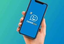 foto mostra mão segurando celular com caixa tem