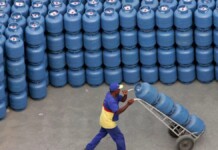 Imagem de homem carregando botijões de gás
