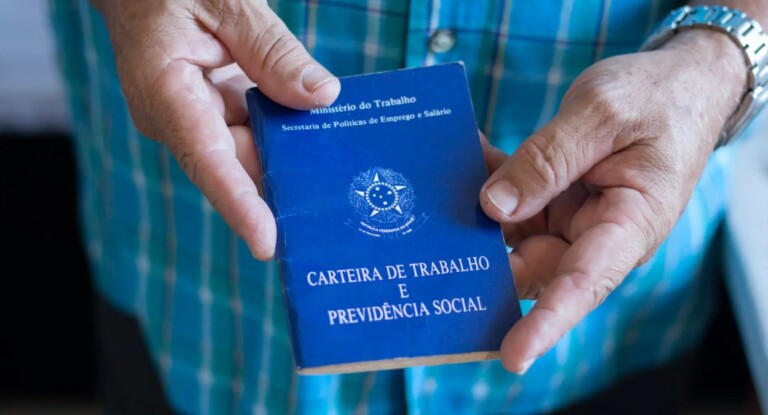 Imagem de um idoso com a carteira de trabalho em mãos