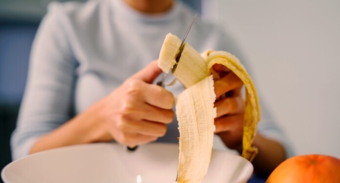 será que a banana faz mal? saiba detalhes na reportagem. Foto de pessoa cortando banana.