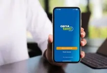 foto mostra pessoa segurando celular com aplicativo do caixa tem