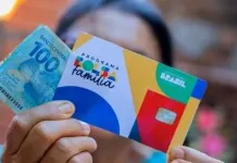 na foto, beneficiário segurando o dinheiro do valor pago pelo Bolsa Família