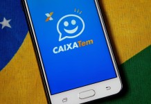 Foto mostra o aplicativo do Caixa Tem em um celular com a bandeira do Brasil de fundo.