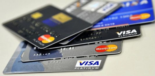 Cliente utiliza cartão de crédito premium durante pagamento em estabelecimento comercial