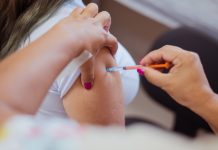 Profissional de saúde aplica vacina contra o HPV em adolescente durante campanha de imunização