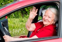 Idoso analisa modelos de veículos em concessionária durante pesquisa para compra de carro zero-quilômetro