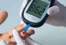 Pessoa segura comprimidos de metformina ao lado de medidor de glicemia utilizado no controle do diabetes